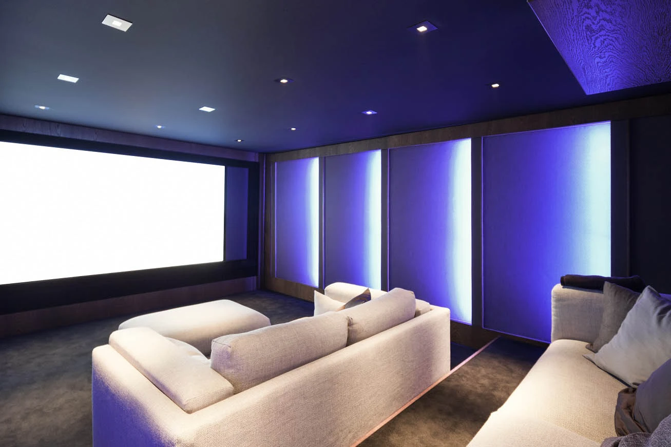 Cozy home theater with couch and projector screen featured in Complete Guide to Home Theatre Lighting - Essential Home Theater Lighting Tips for an Immersive Experience - Vorlane